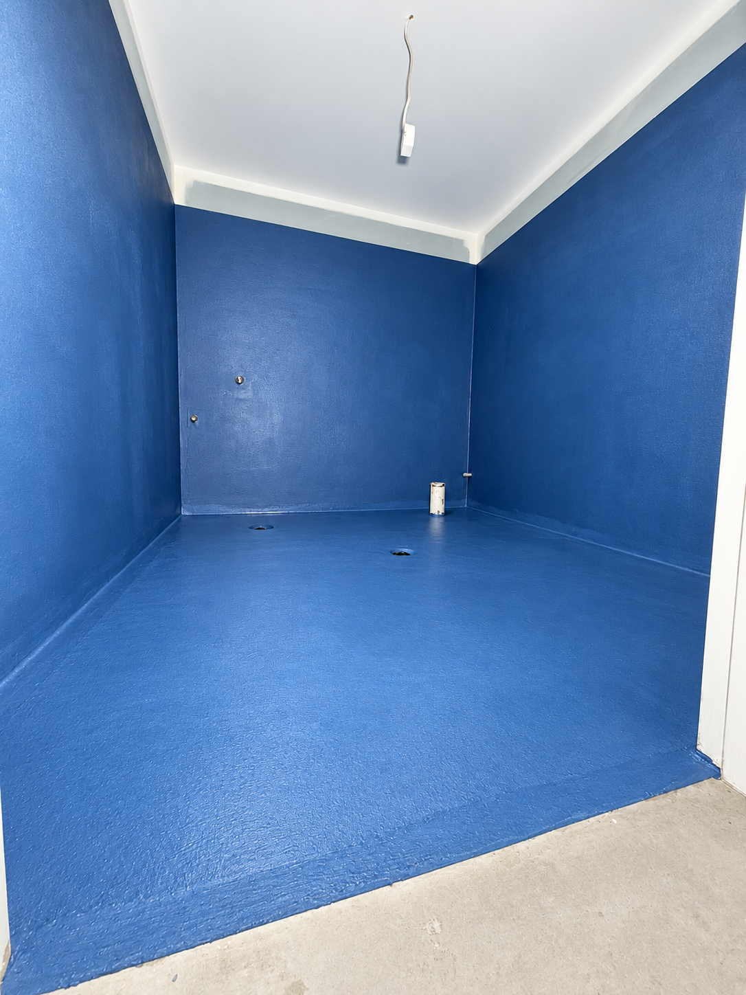 Placeholder: tiler laying a large-format porcelain tile with a notched trowel